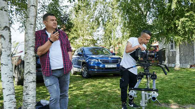 Продюсер с рацией и оператор с камерой среди березок