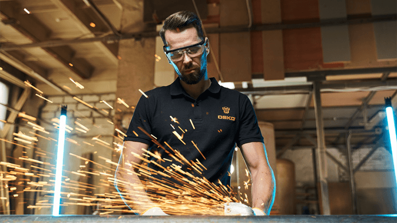 Модный парень работает с болгаркой, искры