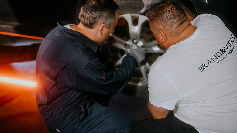 Двое мужчин возятся с колесом машины